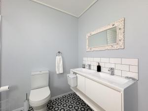 a white bathroom with a toilet and a sink at Swordfish Retreat in St. Helena Bay +20 photos