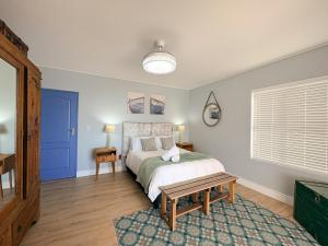 a bedroom with a bed and a blue door at Swordfish Retreat in St. Helena Bay