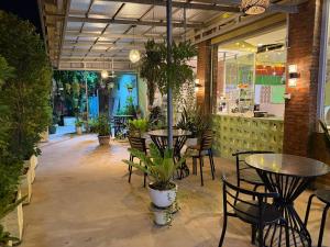 a restaurant with tables and chairs and plants at Mohachey Guesthouse in Phumĭ Bavĕt (2)