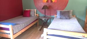 a bedroom with two beds and a table with a lamp at Apartment-double storey-2 bedrooms-own bathroom, kitchen, dining room, entrance, lounge, patio in Pinetown
