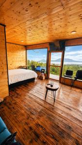 a bedroom with a bed and a table and windows at Casa Jaguar Neusa in Tausa Viejo