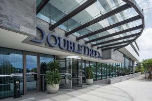 a columbine building with potted plants in front of it at Doubletree By Hilton Lagoa Azores in Lagoa