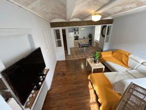a living room with a couch and a flat screen tv at Comme à La Maison in Cayres