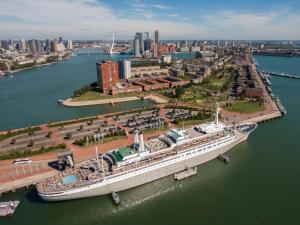 a large cruise ship docked in a harbor at ss Rotterdam by WestCord in Rotterdam