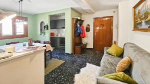 a living room with a couch and a kitchen at Limone Piemonte Kids Friendly in Limone Piemonte