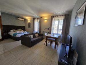 ein Wohnzimmer mit Sofa, Bett und Fernseher in der Unterkunft D Townhouse Boutique Suites in Sliema