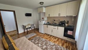 a kitchen with white cabinets and a counter top at Dermendzhiev Apartments Melnik in Melnik