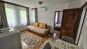 a living room with a couch and a door at Dermendzhiev Apartments Melnik in Melnik
