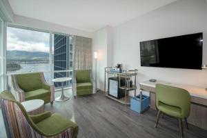 a hotel room with a room with a large window at Coast Coal Harbour Vancouver Hotel by APA in Vancouver