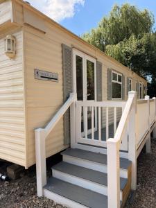 a tiny house with stairs leading to the front door at Swans Rest - Lakeside Caravan Park in Denver