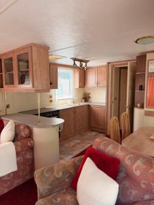 a kitchen and living room with a couch and a table at Swans Rest - Lakeside Caravan Park in Denver +7 photos