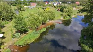 an aerial view of a river with a boat in it at Domki nad rzeką Ełk in Prostki +50 photos