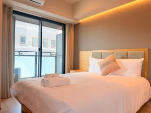 a bedroom with a large bed with towels on it at LuxuryHOTEL難波南 in Osaka