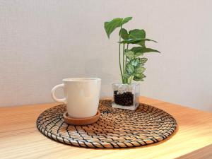 a coffee cup and a potted plant on a table at LuxuryHOTEL難波南 in Osaka