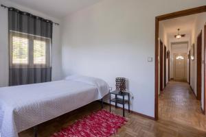 a white bedroom with a bed and a mirror at Casa de Jonathan in Vilarinho do Souto