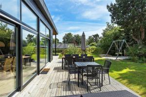 a deck with a table and chairs and a playground at 30159-Odder-Thorasvej-24 in Odder