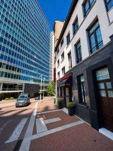 a building with a car parked in front of a street at Hotel Albergo in Brussels
