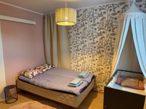 a small bedroom with a bed and a chandelier at Villa Ensola with pool in Savonlinna +31 photos