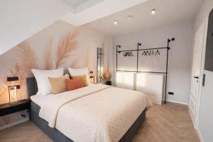 a bedroom with a large bed with white sheets and orange pillows at The Summit Rooftop I Meissen in Meißen