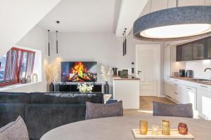 a living room with a couch and a fire in the fireplace at The Summit Rooftop I Meissen in Meißen