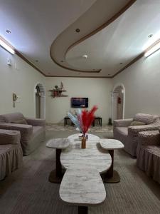 a living room with couches and a table with flowers at شقة واسعة بحي الدوحة لـ 10 أشخاص 6دقائق للبحر in Yanbu