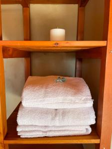 a wooden shelf with towels and a candle on it at Posada La Tregua in El Bolsón