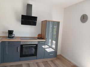 a kitchen with a stove top oven next to a window at Ferienwohnung Sägmühlweiher in Ludwigswinkel