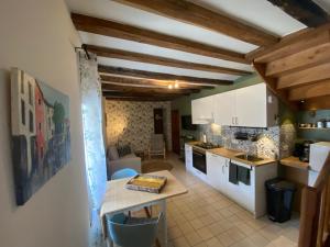 a kitchen with white cabinets and a table in a room at Mon Repos, onze sfeervolle gîte in Haims