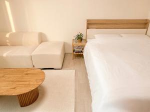 a room with a bed and a couch and a table at Stay Joy in Suwon