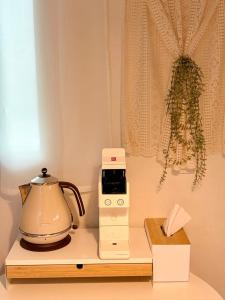 a microwave sitting on a counter next to a tea kettle at Stay Joy in Suwon