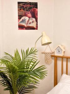 a plant in a bedroom next to a lamp and a book at Stay Joy in Suwon