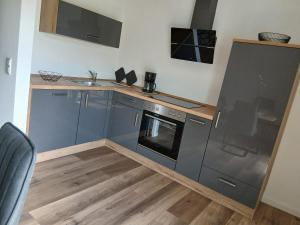a kitchen with a stove and a sink at Ferienwohnung Sägmühlweiher in Ludwigswinkel