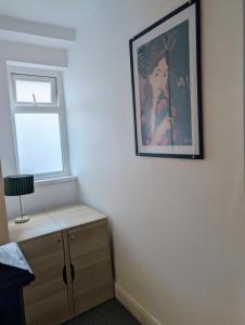 a painting of a woman on a wall next to a window at Ivy Townhouse Derry in Derry Londonderry