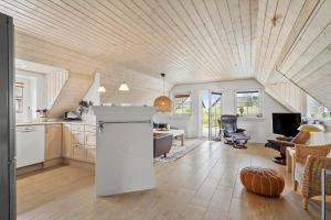 a kitchen and living room with a wooden ceiling at 1126-Ringkobing-Frans-Julius-Vej-44 in Klegod