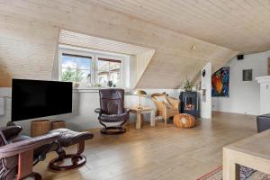 a living room with a flat screen tv and chairs at 1126-Ringkobing-Frans-Julius-Vej-44 in Klegod