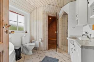 a white bathroom with a toilet and a sink at 1126-Ringkobing-Frans-Julius-Vej-44 in Klegod +46 photos