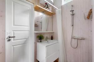 a white bathroom with a sink and a shower at 1605-Dronningmolle-Tarnfalkevej-1 in Dronningmølle