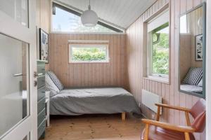 a small bedroom with a bed and a window at 1605-Dronningmolle-Tarnfalkevej-1 in Dronningmølle