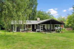 a house with a black roof on a yard at 1605-Dronningmolle-Tarnfalkevej-1 in Dronningmølle