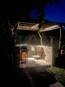 a grill and a stone fireplace in a yard at StNicholas Ranch Corfu Wild Camping in Benitses