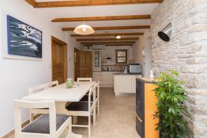 a kitchen and dining room with a white table and chairs at Holiday Homes Baučić in Omiš