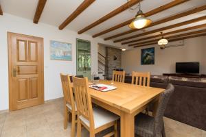 a dining room with a wooden table and chairs at Holiday Homes Baučić in Omiš