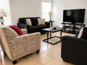 a living room with two couches and a tv at 5BR Florida villa with private pool in Davenport