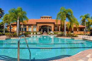 a swimming pool in front of a house with palm trees at 5BR Florida villa with private pool in Davenport