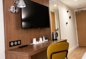 a hotel room with a flat screen tv on a wall at B&B HOTEL Le Havre Centre in Le Havre