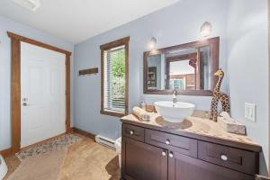 a bathroom with a sink and a giraffe on the counter at Spa Pool table Mountain - Chalet Avalanche in Saint-Philémon