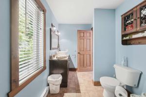 a bathroom with a toilet and a sink and a window at Spa Pool table Mountain - Chalet Avalanche in Saint-Philémon