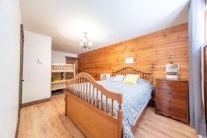 a bedroom with a bed and a wooden wall at Spa Pool table Mountain - Chalet Avalanche in Saint-Philémon