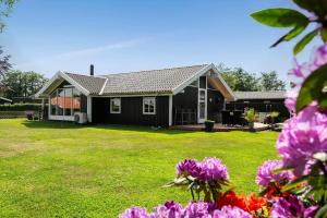 a house with purple flowers in the yard at 30510-Odder-Elmegaardsvej-8 in Odder