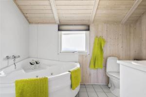a bathroom with a tub and a toilet and a window at 30510-Odder-Elmegaardsvej-8 in Odder +26 photos